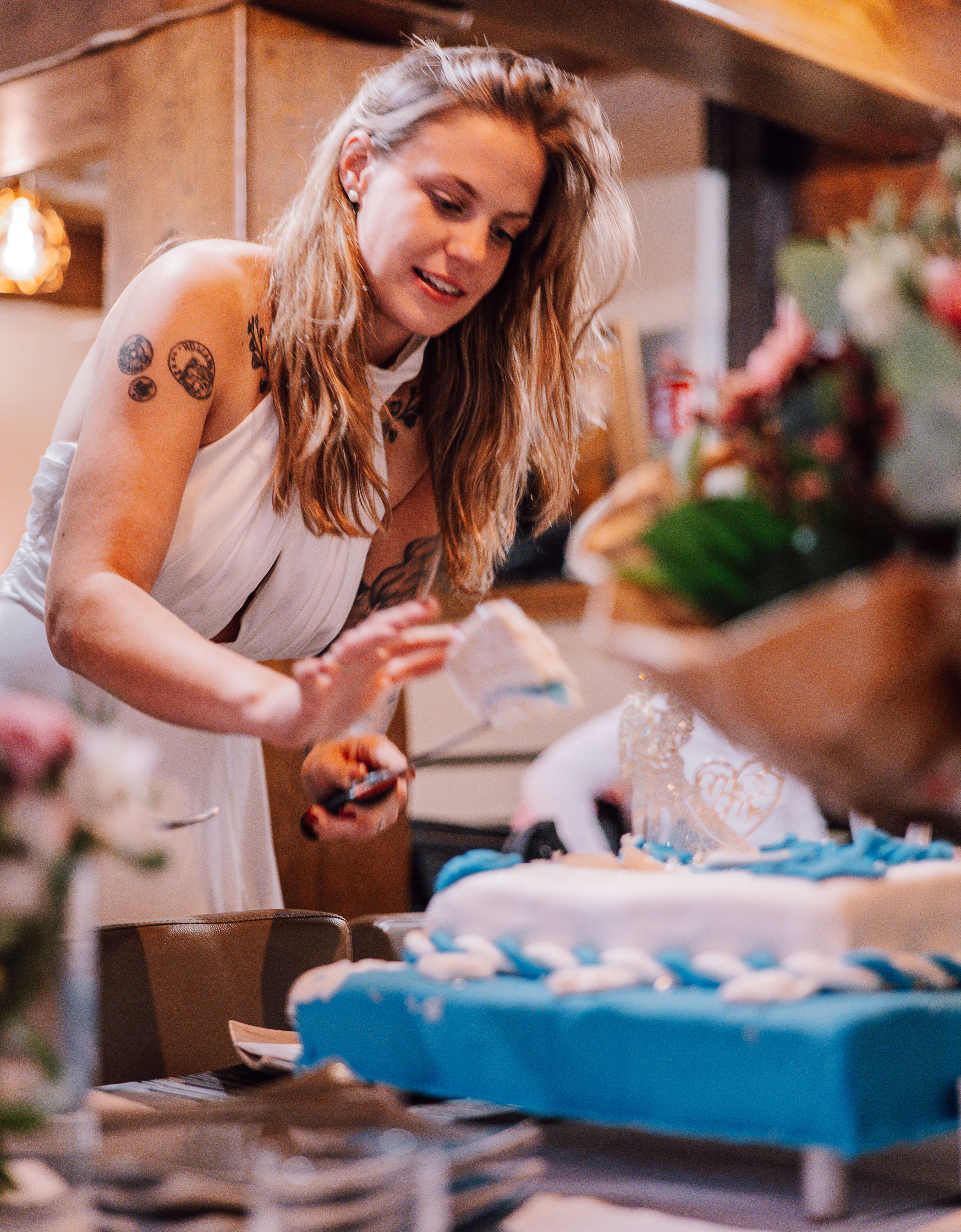 junge Braut schneidet Hochzeitstorte an 