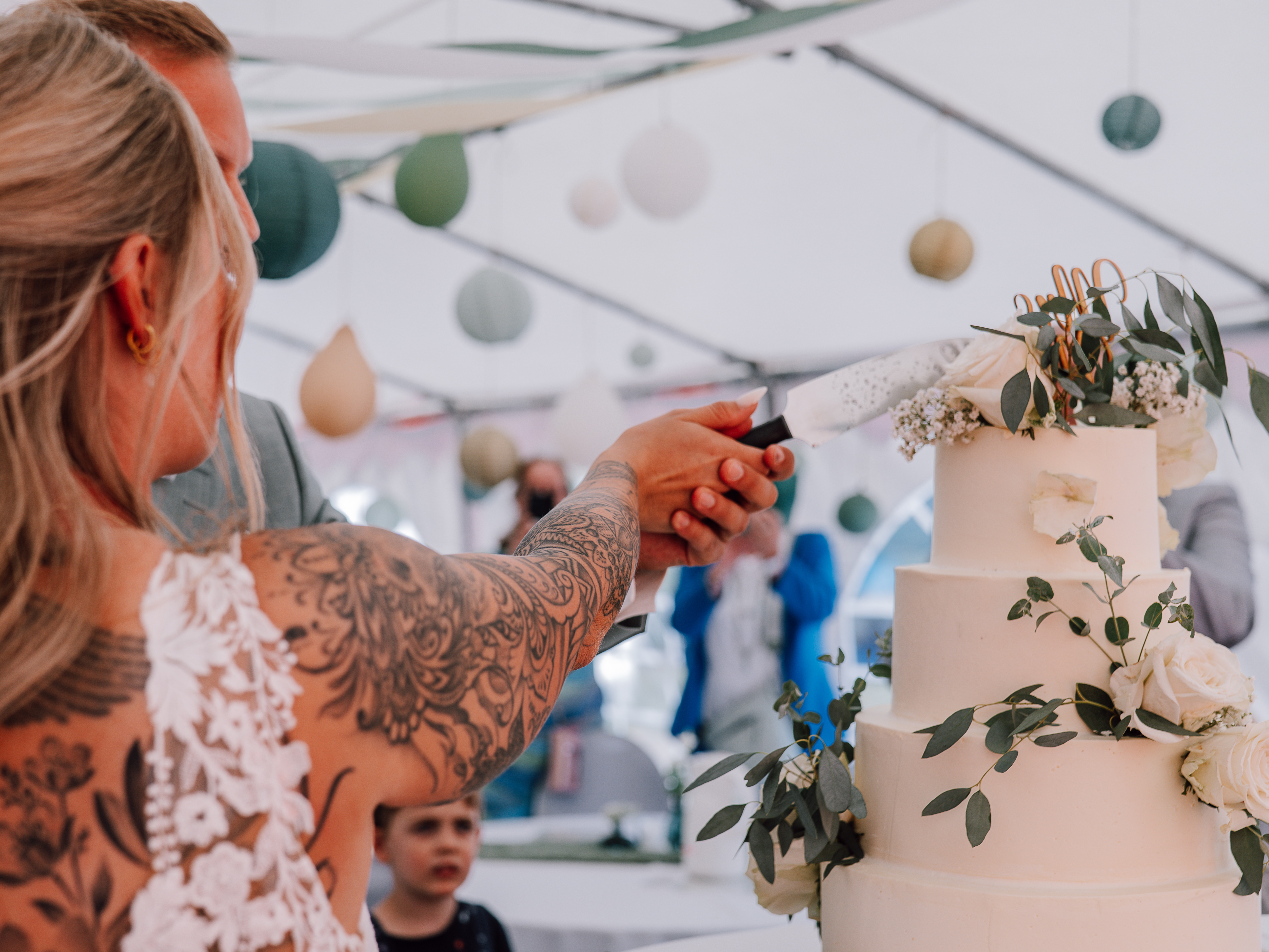 Brautpaar schneidet gemeinsam Hochzeitstore an, Hochzeitsfotografie